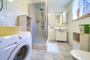 a bathroom with a washing machine and a shower at Kuca za odmor Kornic in Kornić