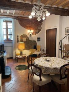 a living room with a table and chairs and a chandelier at Casetta Marilà in Lucignano