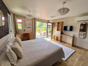a bedroom with a large bed and a desk at Le jardin des 4 saisons in Le Mans