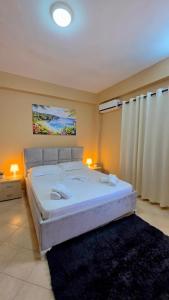 a bedroom with a large white bed with a black rug at Villa Alvara in Vlorë +19 photos