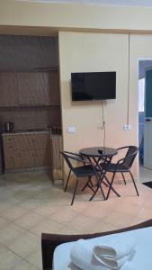 a table and chairs in a room with a tv at Villa Alvara in Vlorë