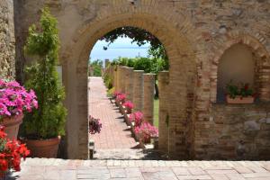 an archway in a stone wall with flowers in pots at Suite in Centro in Vasto