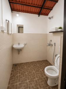 a bathroom with a toilet and a sink at Vinsons Cottages in Colva +27 photos