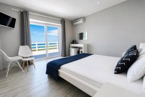 a bedroom with a large bed and a large window at AGATA BEACH Boutique -Adult Only in Ahtopol