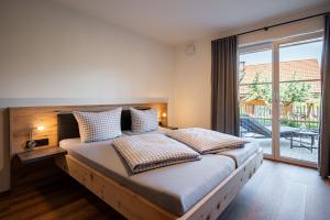 a bedroom with a large bed with a large window at Alpenrose in Obermaiselstein