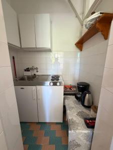 a small kitchen with a sink and a stove at Studio Apartmani ISRA in Palit