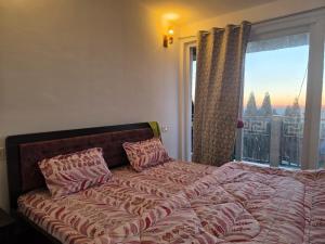 a bedroom with a bed with a large window at The Dusk Stay in Sonāda