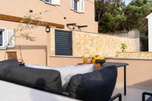 a patio with a couch and a table and a wall at Casa Duea Sorores in Osredina