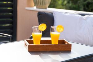 two glasses of orange juice in a wooden tray on a table at Casa Duea Sorores in Osredina