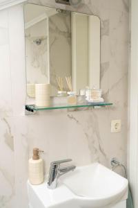 a white bathroom with a sink and a mirror at Casa Duea Sorores in Osredina +26 photos
