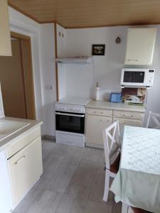 a kitchen with white cabinets and a stove top oven at Ferienwohnung Jahner in Reinhardtsdorf