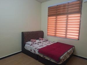 a small bed in a room with a window at Jeda Salihah in Baling