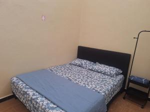 a small bedroom with a bed with blue sheets at Jeda Salihah in Baling