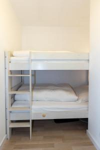 a bunk bed with white bunk beds in a room at Hanseatic 110 in Duhnen