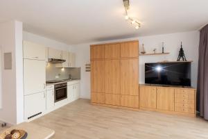a kitchen with a large wooden cabinet with a flat screen tv at Hanseatic 110 in Duhnen