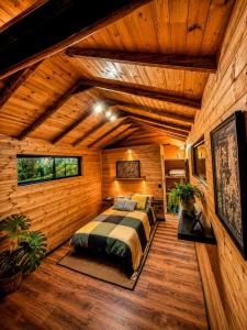 a bedroom with a bed in a room with wooden walls at Basecamp Colombia in Carmen de Carupa