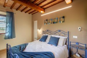 a bedroom with a bed with blue and white pillows at Agriturismo Marinello in Pienza