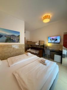 a bedroom with a large white bed and a desk at DAD Vogelweiderhof Rooms in Salzburg