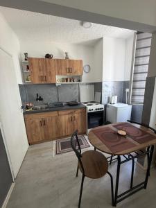a small kitchen with a table and a table and chairs at Apartman Velić in Bor