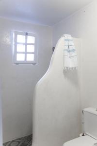 a white bathroom with a toilet and a window at White Blue Villa formerly Ippocampi in Koutouloufari +45 photos
