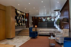 a lobby with blue chairs and a table and stairs at The Democracy Hotel & Resorts Convention Center in Nashik