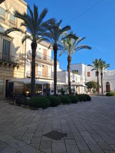 a group of palm trees in front of a building at Domus Solis Salento in Campi Salentina