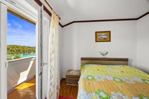 a bedroom with a bed and a view of the ocean at Apartments Petra - 100 m from the Beach in Kampor