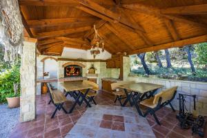 an outdoor kitchen with tables and a fireplace at Apartments Petra - 100 m from the Beach in Kampor