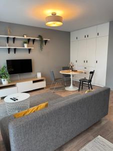 a living room with a couch and a table at Di Trevi Apartment in Wrocław +3 photos