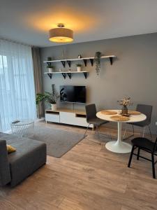 a living room with a table and a couch at Di Trevi Apartment in Wrocław