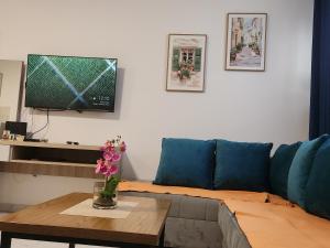 a living room with a blue couch and a table with flowers at DD Apartmani in Sutorina