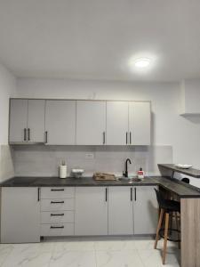 a kitchen with white cabinets and a sink at DD Apartmani in Sutorina