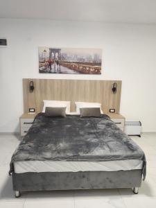 a bedroom with a large bed with a painting on the wall at DD Apartmani in Sutorina
