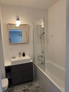 a bathroom with a sink and a shower and a toilet at Di Trevi Apartment in Wrocław