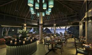 a restaurant with tables and chairs and a large chandelier at Pimalai Resort & Spa in Ko Lanta