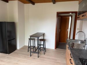a kitchen with two bar stools and a black refrigerator at Zimmer im Erdgeschoß mit Bad und Küche in Minden +2 photos