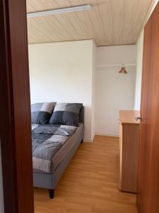 a bedroom with a bed and a wooden floor at Zimmer im Erdgeschoß mit Bad und Küche in Minden