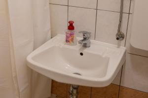 a white sink with a bottle of soap on it at Apartments Jurina 2 in Krk +15 photos