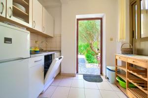 a kitchen with a door leading to a yard at Apartments Jurina 2 in Krk