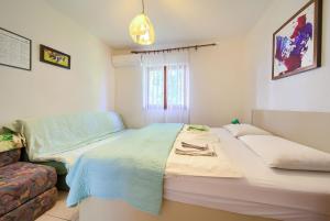 a bedroom with a large bed and a couch at Apartments Jurina 2 in Krk