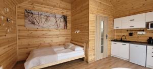 ein Schlafzimmer mit einem Bett in einer Holzwand in der Unterkunft Gemini MiniDomki in Ustka