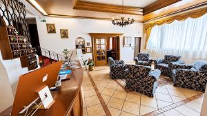 a living room with couches and a table with a laptop at Hotel Regina Delle Dolomiti in Panchià