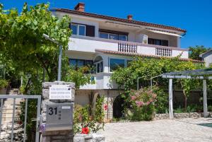 a house with a sign in front of it at Apartments Jurina 2 in Krk