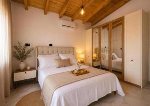 a bedroom with a large white bed with a tray on it at Meis Villas in Dhërmi