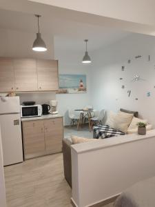 a kitchen and living room with a couch and a refrigerator at Ioanna Studio Διαμέρισμα κοντά στη θάλασσα. in Kolymbia