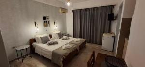 ein Hotelzimmer mit zwei Betten und einem Fernseher in der Unterkunft Villa Manolis in Tolo