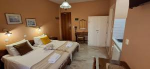 ein Hotelzimmer mit zwei Betten und einem Tisch in der Unterkunft Villa Manolis in Tolo