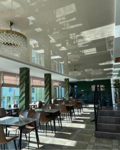 a dining room with tables and chairs and windows at Inn David in Chakvi