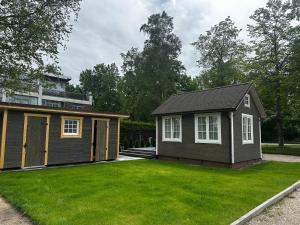 a small house with a green lawn in front of it at Melluži tiny house 35m2 in Jūrmala