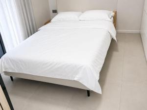a large white bed with white sheets and pillows at Spacious 2-Bedroom Family Suite with Pool & Garden View in Moka +35 photos